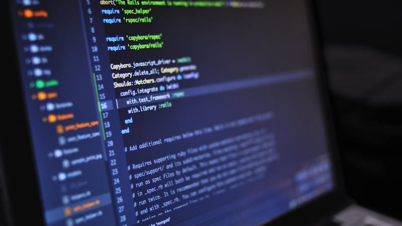 TypeScript code displayed on a monitor showing database query operations