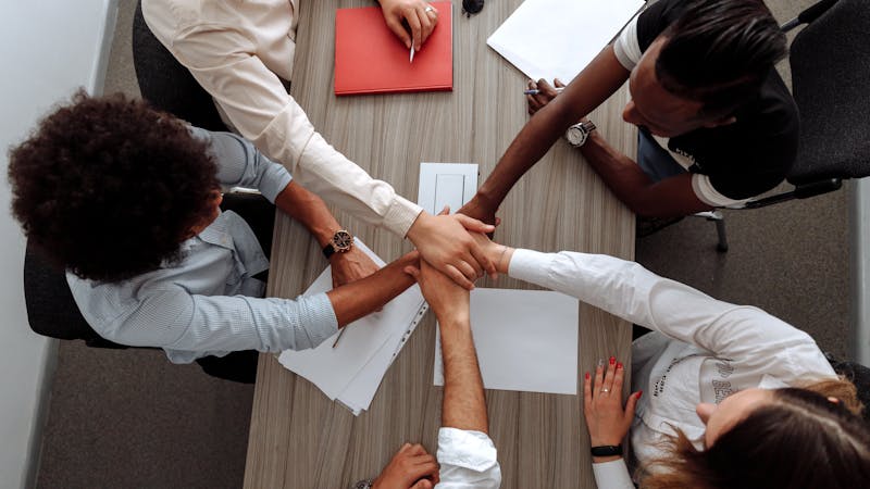 Team members collaborating together around a shared workspace