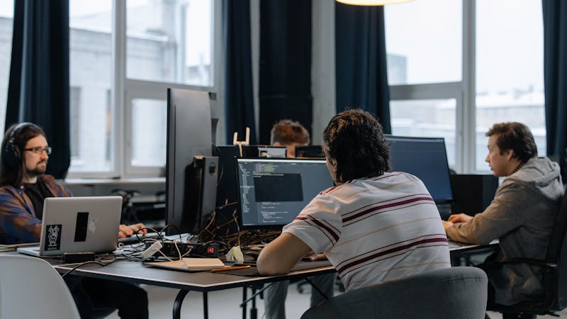Software development team collaborating on a project at their workstation