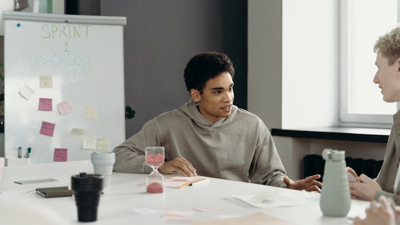 Team gathered around a table during a sprint review meeting discussing project progress